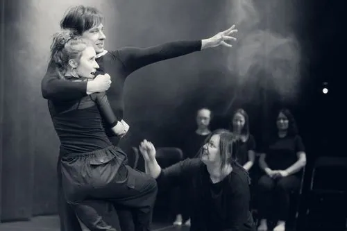 Performerka wyciąga rękę w smudze dymu
